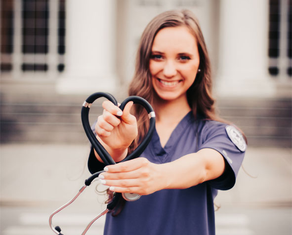 Haleigh Barrett holding up her stethoscope in shape of a heart.